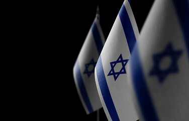 Small national flags of the Israel on a black background