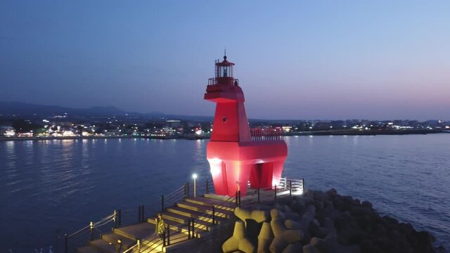 Aerial View Sunset at the ocean with horse-shaped Lighthouse in Jeju Island