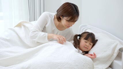 子供を寝かしつけるお母さん