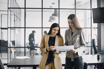 Multi-ethnic business colleagues reviewing paper documents while standing in modern office