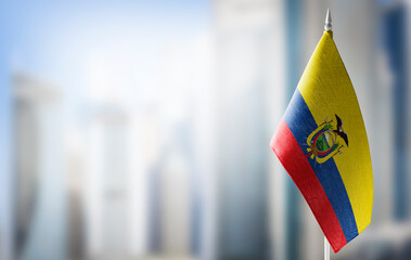 A small flag of Ecuador on the background of a blurred background