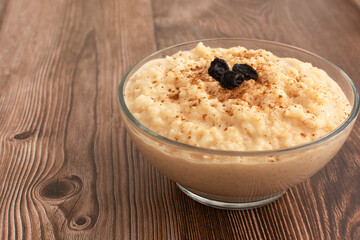 Tazón de arroz con leche sobre mesa de madera. Postre delicioso hecho en casa, saludable.