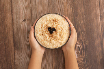 Tazón de arroz con leche sobre mesa de madera. Postre delicioso hecho en casa, saludable.