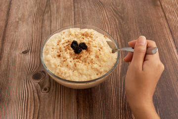 Tazón de arroz con leche sobre mesa de madera. Postre delicioso hecho en casa, saludable.