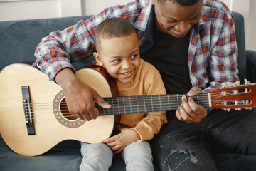 Father teaches his son to play guitar