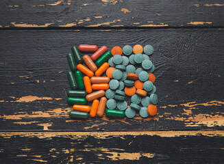 Different pills on dark wooden background