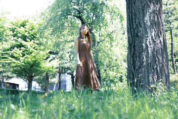 Fototapeta na wymiar 木々の小道で佇む美しい女性のポートレート