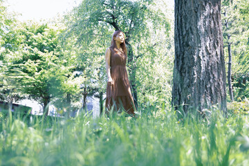 Fototapeta na wymiar 木々の小道で佇む美しい女性のポートレート