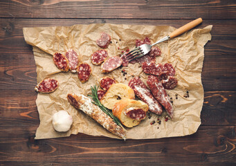 Tasty slices of salami on wooden background