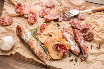 Tasty slices of salami and bread on parchment