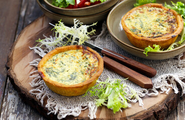 mini quiche com espinafre em uma placa de madeira, estilo rústico. 