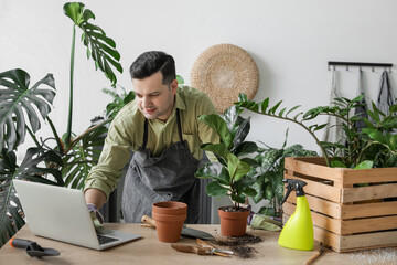 Male gardener with laptop at home