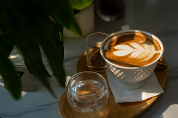 Hot coffee latte with latte art milk foam in cup mug with on marble floor background table In a coffee shop at the cafe