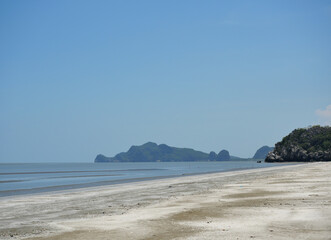 Sand and mud in water phenomenon, Fishing boat on the beach , Ocean waves splash the shore severely , Bay with mountain at Khao Sam Roi Yot national park , Thailand