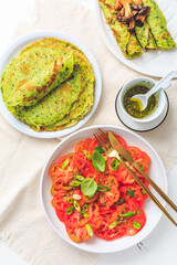 Tomato salad with onions and ramson pancakes or crepes