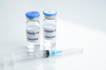 Two Vial of Covid-19 vaccine  with syringe   on white glass  medical background