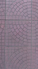 fragment of reddish-pink natural stone pavement with geometric masonry top view, full frame graphic resource of city square tiles, stone backdrop of cobbled street surface view from top corner