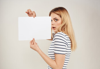 Cute blonde model with white sheet of paper in hands