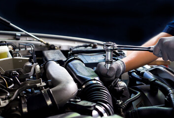 Obraz na płótnie Canvas A car mechanic is doing a car repair in a repair shop.