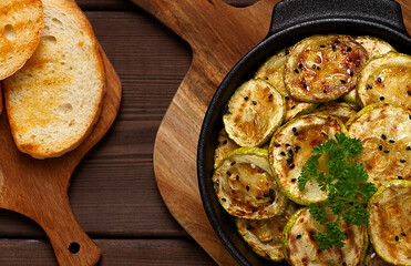 Grilled zucchini, with spices, top view, on a wooden brown table, horizontal, no people,
