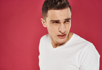 Obraz premium man in white t-shirt close-up red background dissatisfaction