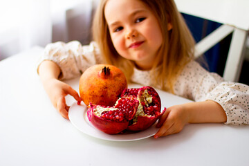 Little girl holding a pomegranate. Symbol of the Jewish New Year. Rosh ha Shana. Healthy organic sweet fruits. 