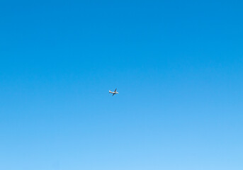 Naklejka na ściany i meble a white plane in a blue sky