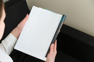 Hand holds white magazine with blank cover mock up. Hand in shirt hold clear magazine mockup...
