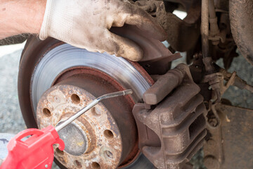 Car mechanic repairing brakes on car