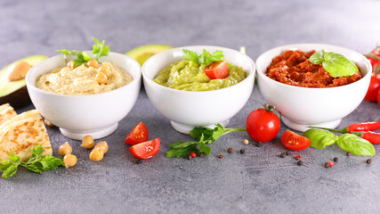 set of dipping sauce- hummus,  guacamole,  tomato tapenade