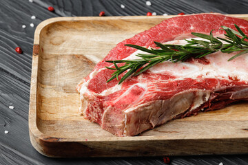 Uncooked raw beef brisket on wooden board