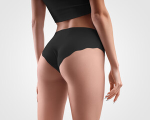 Mockup of black seamless panties on slim girl isolated on background in studio