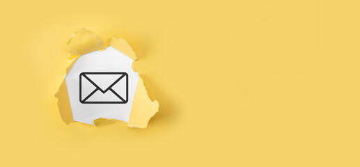 Torn yellow paper with letter email icon on white background.Email marketing and newsletter...