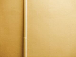 Concrete wall and a straight line pipe with Fortuna gold color