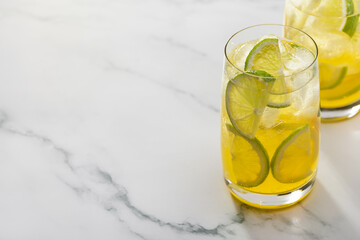 Two glasses of refreshing lemonade with lime and lemon. Copy space, marble background.