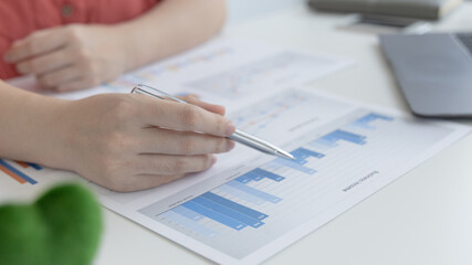 Asian women are analyzing graphs, market data and assessing investment risks, Working at home during the outbreak of the virus or social spacing, Refraining from spreading germs.