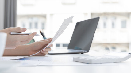 Asian women are analyzing graphs, market data and assessing investment risks, Working at home during the outbreak of the virus or social spacing, Refraining from spreading germs.