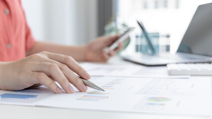 Asian women are analyzing graphs, market data and assessing investment risks, Working at home during the outbreak of the virus or social spacing, Refraining from spreading germs.