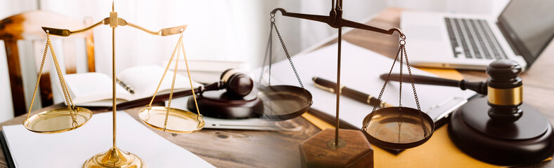 Justice and law concept.Male judge in a courtroom with the gavel, working with, computer and docking keyboard, eyeglasses, on table in morning light