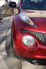 Obraz na płótnie Canvas Car headlights. Red car exterior closeup detail