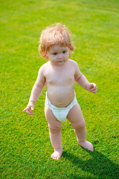 Happy Baby Running In A Spring Field And Wearing A Diaper. First Step.