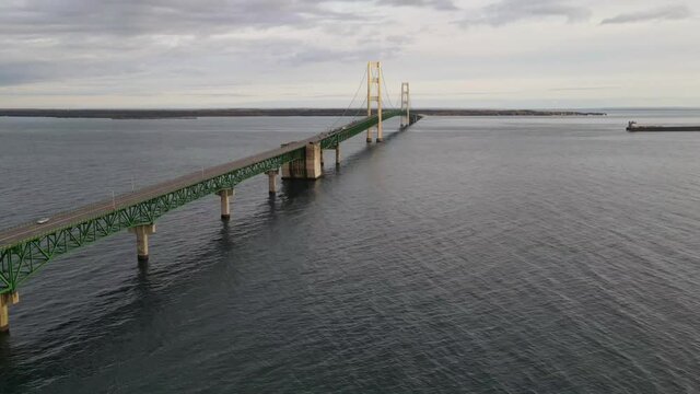 4k drone time lapse video of freighter passing by Mackinac Bridge in Michigan.