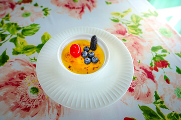 The fruit cake plate is placed on the light brown table. The plate is beautifully decorated.