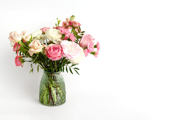 Beautiful flowers in vase on a table with white background. Women's, mother's day, love concept. Spring, summer season.