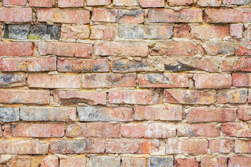 An old brick wall with dirty broken bricks