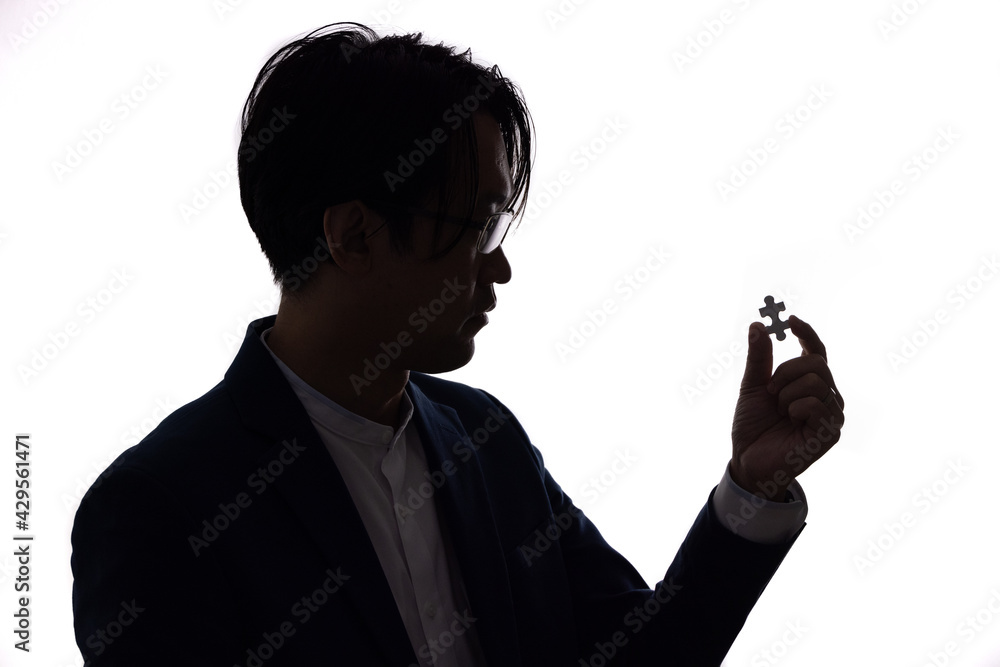 Aufkleber silhouette of close up businessman hold jigsaw piece isolate on white background. business concept o