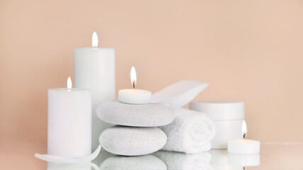 Fototapeta na wymiar Beauty products with Towel, candles and white stone on color background. Beauty spa treatment and relax concept.