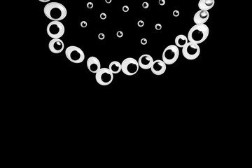 A circle of toy eyes. filled with small eyes on a black background