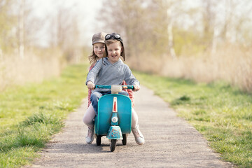 zwei Kinder fahren mit dem Tretroller