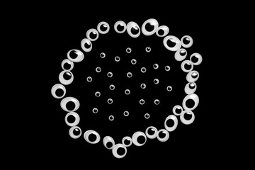 A circle of toy eyes on a black background